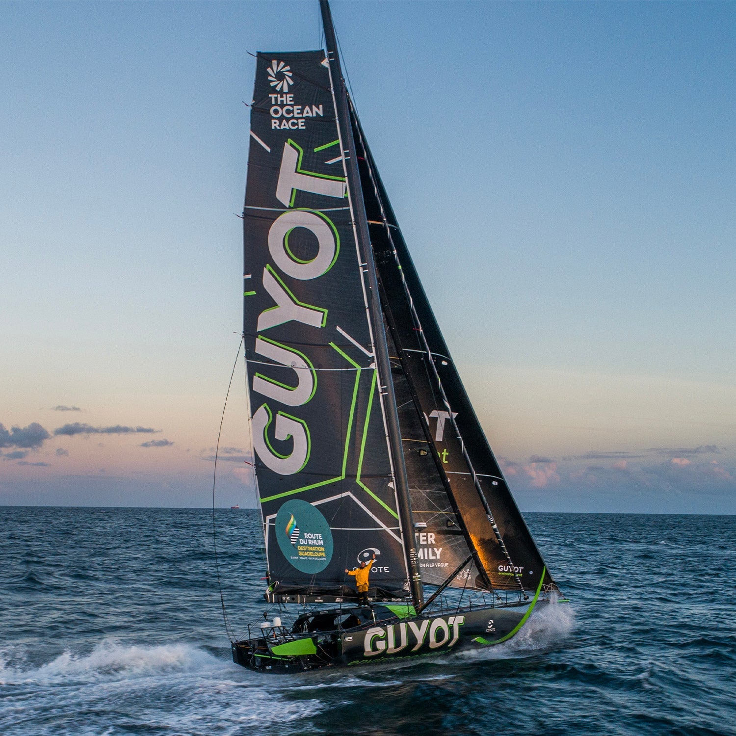 Team Guyot's green and black boat out on the ocean during a beautiful sunset in the background.//© Team Guyot | Charles Drapeau - ILP Vision