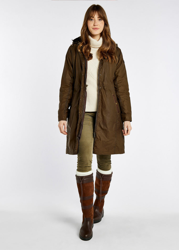 On Model image of a woman wearing narrower calf fitting Dubarry Ladies knee-high walnut brown leather Galway Country Boot with laced top. She is also wearing a brown wax jacket, cream knitted jumper and green honeysuckle jeans.