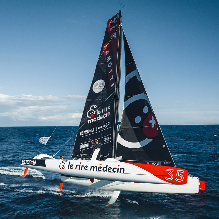 Square image of Luke Berry's boat at sea on it's side gliding through the blue water on a sunny day//© Luke Berry | Pierre Bouras - Lamotte Module Creation